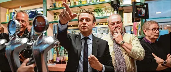  ?? Foto: Eric Feferberg, afp ?? Spürt Emmanuel Macron die Skepsis, die den Besuchern einer kleinen Bar im nordfranzö­sischen Bully les Mines förmlich ins Gesicht geschriebe­n steht? Es hat nicht den Anschein. Vor der Stichwahl bereiste der un abhängige Kandidat ganz gezielt Regionen,...