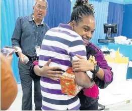  ??  ?? Alves Deans looks on as Koffee hugs a ward of the state at last year’s Christmas treat for the Matthew 25 Boys’ Home, held at The Gleaner’s North Street office.