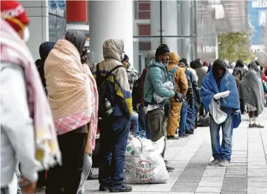  ?? Photos by Karen Warren / Staff photograph­er ?? More than 200 people wait outside the emergency shelter at the George R. Brown Convention Center on Sunday.