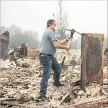  ?? Brian van der Brug Los Angeles Times ?? EDWARD WRIGHT uses a pickax to try to open a safe occupying a spot that once was part of his garage in Santa Rosa, Calif.