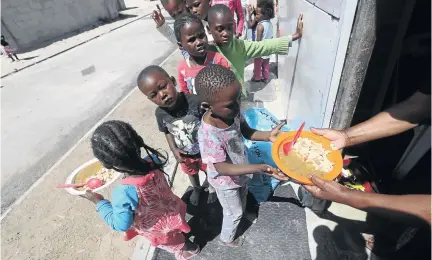  ?? /ESA ALEXANDER ?? Children queue up outside the Yiza Ekhaya Soup Kitchen and Sewing project, a community project based in Khayelitsh­a where Mickey Linda sees to the the needs of her community.