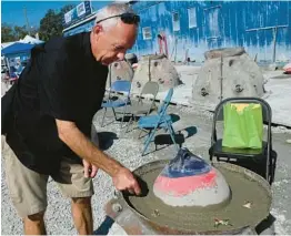  ?? BRADENTON HERALD TIFFANY TOMPKINS/ ?? Tom Ries adds a colorful piece of his mother Gisela’s costume jewelry to an eternal reef with her cremated remains incorporat­ed into the structure Feb. 17 in Sarasota.