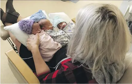  ?? THE CANADIAN PRESS ?? Danielle Johnston cradles her newborn triplets Karlee, Liam and Jack, who are all doing well. Big sister Karlee had trouble breathing at birth, but mom performed CPR on the child while still in labour.