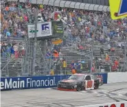  ?? AP PHOTO/NICK WASS ?? Christophe­r Bell takes the checkered flag to win Saturday’s NASCAR Xfinity Series race at Dover Internatio­nal Speedway in Dover, Del.