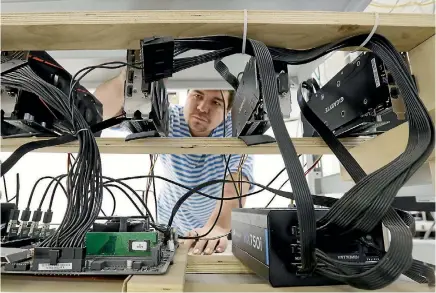  ?? PHOTO: GETTY IMAGES ?? A technician works on hardware at the SberBit cryptocurr­ency mining equipment facility.