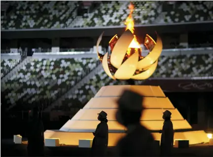  ?? DAVID GOLDMAN - THE ASSOCIATED PRESS ?? Volunteers stand as Internatio­nal Olympic Committee’s President Thomas Bach gives a speech during the closing ceremony in the Olympic Stadium in Tokyo, Japan, on Sunday, Aug. 8.