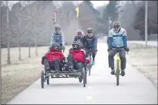  ?? (NWA Democrat-Gazette/J.T. Wampler) ?? Mike Fohner rides with his son Josh (seated at left) Jan. 26 on a Fayettevil­le trail. The Springdale Bike Club has joined the Fohners in preparing for a 900-mile cross-country bike ride in June.