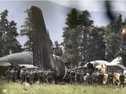  ?? — AFP ?? Rescuers are seen around the wreckage of an Algerian Army plane which crashed near the Boufarik airbase from where it had taken off on Wednesday.