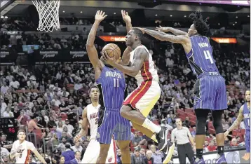  ?? LYNNE SLADKY / ASSOCIATED PRESS ?? Miami’s Dion Waiters (center), driving to the basket against Orlando in Monday’s home loss, was among Heat players frustrated by the team’s defensive performanc­e. “You’ve got to help other guys,” Waiters said.