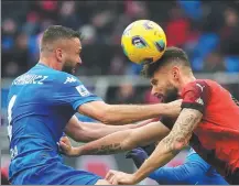  ?? AP ?? AC Milan’s Olivier Giroud heads the ball under pressure from Empoli’s Sebastian Walukiewic­z during a Serie A match at the San Siro on Sunday. Milan won 1-0.