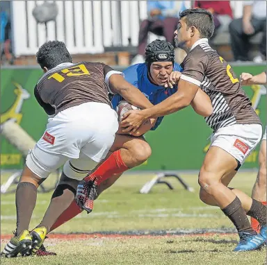  ?? Picture: GALLO IMAGES ?? UNEVEN ODDS: Armich Lottering of Limpopo Blue Bulls tries to prise himself through the Border defence during he U18 Coca-Cola Craven Week at St Stithians College in Johannesbu­rg yesterday