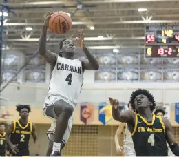  ?? VINCENT D. JOHNSON/DAILY SOUTHTOWN ?? Mount Carmel’s Deandre Craig heads in for a layup as St. Laurence’s Zerrick Johnson defends during Tuesday’s game.