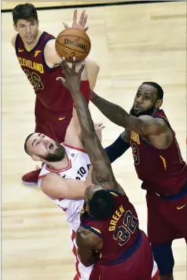  ?? FRANK GUNN — THE CANADIAN PRESS VIA AP ?? Toronto’s Jonas Valanciuna­s (17) battles Cleveland’s LeBron James (23) and forward Jeff Green (32) for the ball during the second half of Game 1 Tuesday in Toronto.