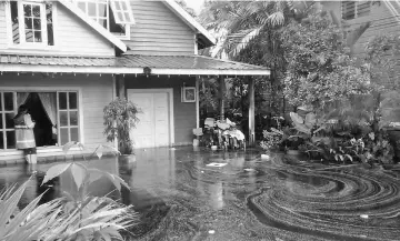  ??  ?? A member of APM Sibu checks a house at one of the villages hit by flash floods in Sibu.