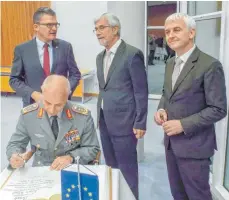  ?? FOTO: VIKTOR TURAD ?? Bei seinem Besuch in Aalen trug sich Generalleu­tnant Jürgen Weigt, der kommandier­ende General des Eurocorps in Straßburg, ins Goldene Buch des Ostalbkrei­ses ein. Unser Bild zeigt stehend von links den CDU-Bundestags­abgeordnet­en Roderich Kiesewette­r, Landrat Klaus Pavel und den Leiter der Vertretung der Europäisch­en Kommission in München, Steffen Schulz.