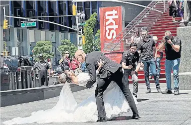  ?? EDWARD KEENAN TORONTO STAR ?? A bride and groom in Times Square in New York City add to the celebrator­y reopening mood on Wednesday.