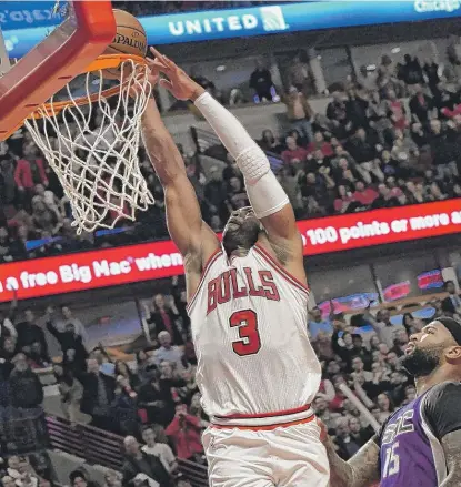  ??  ?? Bulls guard Dwyane Wade gets a huge foul call as he goes up for a dunk against Kings big man DeMarcus Cousins. | DAVID BANKS/ AP