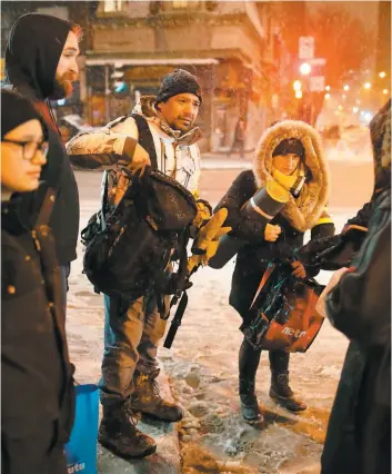  ?? PHOTO DARIO AYALA/AGENCE QMI ?? L’ancien sans-abri Al Harrington, au centre, avec des bénévoles de son escouade il y a deux semaines sur la rue Sainte-Catherine lors d’une patrouille avec le 24 Heures.