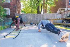  ?? MICHAEL M. SANTIAGO/PITTSBURGH POST-GAZETTE VIA AP ?? During the pandemic, Damiene Palmer, right, and Gerald Sherrell work out outside Sherrell’s home in Bellevue, Pennsylvan­ia.