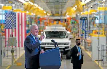  ?? AP PHOTO/EVAN VUCCI ?? Above: President Joe Biden speaks in 2021 during a visit to the General Motors Factory Zero electric vehicle assembly plant in Detroit. Below: On Feb. 8, a solitary Tesla EV leads mostly internal combustion traffic across the Brooklyn Bridge and into lower Manhattan in New York.