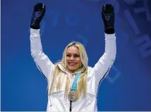  ?? ANDREAS RENTZ / GETTY IMAGES ?? Lindsey Vonn celebrates during the medal ceremony Wednesday after earning bronze in the downhill. Italy’s Sofia Goggia won the gold, and Norway’s Ragnhild Mowinckel took the silver.