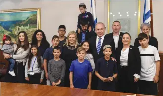  ?? (Kobi Gideon/GPO) ?? PRIME MINISTER Benjamin Netanyahu and his wife, Sara, meet with IDF widows and orphans at the Prime Minister’s Office on Wednesday.