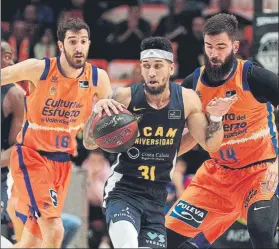  ?? FOTO: EFE ?? Askia Booker, defendido por Vives y Dubljevic. El Valencia no dio opción al UCAM