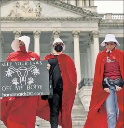  ?? ?? Defining dystopia down: Pro-Roe protesters in “Handmaid’s Tale” outfits, when they’d face prison for this in a true anti-woman land.