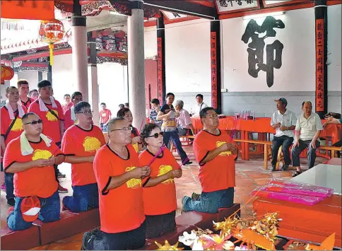  ?? LU JUNJIE / FOR CHINA DAILY ?? Huang Chi-tsung (front left) and members of his extended family pray in the Huang ancestral temple in Pujin, Fujian province.