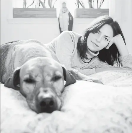  ?? TONY CENICOLA NEW YORK TIMES ?? Patricia Garcia-Gomez and her Rhodesian ridgeback, Sylvie, at her home in New York, in 2011. Garcia-Gomez was recuperati­ng when the dog surprised her by joining her in bed. She enjoyed the comfort and the dog has joined her ever since.