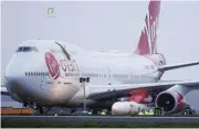  ?? /Reuters ?? Grounded: Cosmic Girl, a Virgin Boeing 747-400, sits on the tarmac with Virgin Orbit’s LauncherOn­e rocket attached to its wing, in January. The rocket did not reach orbit.