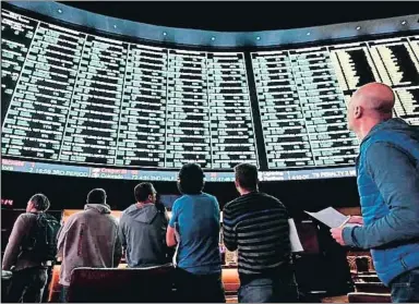  ?? ETHAN MILLER ?? En los casinos de Las Vegas, los jugadores siguen en paneles gigantes el desarrollo de los partidos