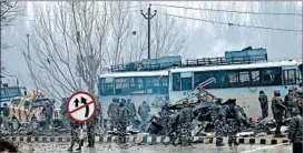  ?? UMER ASIF/AP ?? Indian paramilita­ry soldiers survey bus wreckage after an attack Thursday in Kashmir.