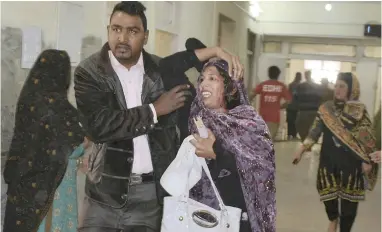  ?? PICTURE: AP ?? A man helps a woman who was injured in the suicide attack on a church in Quetta, Pakistan, yesterday. Two suicide bombers attacked the church when hundreds of worshipper­s were attending services before Christmas.