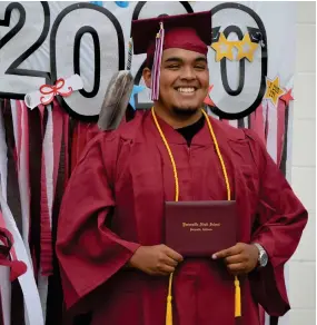  ??  ?? Stronghear­t Garfield smiles big as he shows off his newly received diploma during the Portervill­e Adult School drive-thru graduation ceremony on Monday morning.