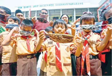  ?? ANGGER BONDAN/JAWA POS ?? JUGA DIJUAL: Guru dan siswa SDN Banyu Urip 3 mengenakan masker yang terbuat dari kain perca.