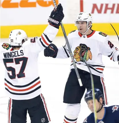  ??  ?? Tommy Wingels and Brandon Saad celebrate Wingels’ goal in the Hawks’ big first period Thursday against the Jets. | JOHN WOODS/ AP