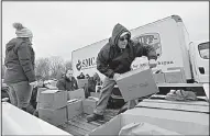  ?? AP/The Herald-Palladium/DON CAMPBELL ?? Volunteers load turkeys and food boxes Thursday for a holiday food program at the Southwest Michigan Community Action Agency’s warehouse in Benton Harbor, Mich. The program collects and distribute­s 400 turkeys and other food to needy people.