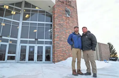  ?? EBONY COX / MILWAUKEE JOURNAL SENTINEL ?? Brothers Rhett, 40, and Zachary Ray Engelking, 38, pose for a portrait in front of West Bend High School where their father, Ray, retired in 2005. In memory of their father, the Engelkings set up a scholarshi­p fund that helps at-risk West Bend West students.