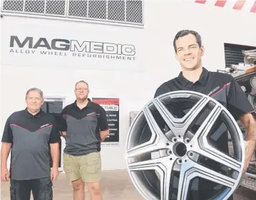  ?? TOP TEAM: Magmedic Alloy Wheel Refurbishm­ent owner Jordan Williams holds an alloy wheel in front of his premises with wheel repair technician­s Rick Williams ( left) and Daniel Faulkner. ??