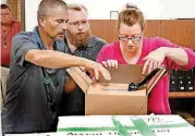  ?? [PHOTO BY JIM BECKEL, THE OKLAHOMAN] ?? Isaac Caviness, left, and Josh Lewelling with Green the Vote deliver a box containing petitions for State Questions 796 and 797 on Aug. 8 to an administra­tive assistant to the secretary of state.