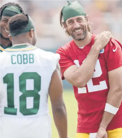  ?? MATT LUDTKE/AP ?? Packers’ quarterbac­k Aaron Rodgers shares a laugh with receivers Davante Adams and Randall Cobb during training camp.