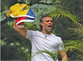  ?? THE ASSOCIATED PRESS ?? Venezuelan opposition leader Leopoldo Lopez waves a national flag Saturday as he greets supporters gathered outside his home after being sent from prison to house arrest.
