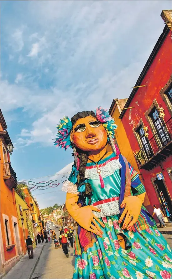  ?? Los Angeles Times ?? A mojiganga — an oversize puppet often seen at festivals — strolls downtown San Miguel de Allende, Mexico. Christophe­r Reynolds