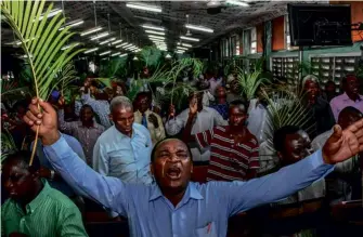  ??  ?? ABOVE: Believers pray without social distancing during a Palm Sunday mass in Dar es Salaam. BELOW: President Magufili has allowed places of worship to stay open – as well as recommendi­ng the use of onions.