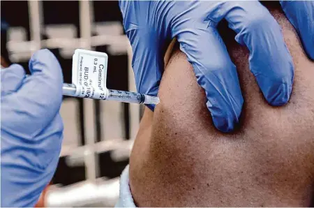 ?? Salgu Wissmath/The Chronicle 2022 ?? UCSF nurse Nicole Parks delivers a coronaviru­s vaccine shot in August as part of a community effort to vaccinate people in the Tenderloin in San Francisco.