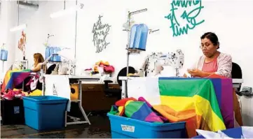  ??  ?? Magdalena Dominguez sews pride flags at R&S Marching Arts in Chicago on Thursday.