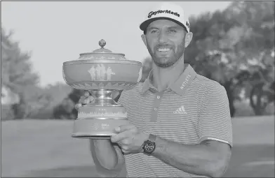  ?? Associated Press ?? Big winner: Dustin Johnson poses with his trophy after defeating Jon Rahm, of Spain, at the Dell Technologi­es Match Play at Austin County Club, Sunday in Austin, Texas.