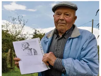  ??  ?? Raymond Foucault, 86 ans, pose avec la photo du soldat Curtis, le pilote américain dont l’avion s’est crashé le 13 juin 1944 dans un champ à Briouze.