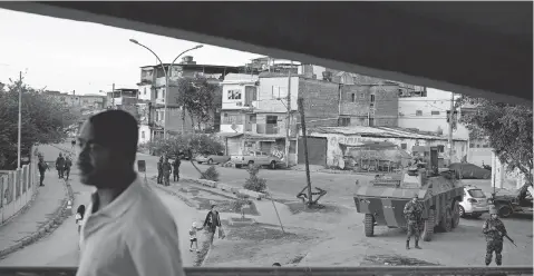  ?? FELIPE DANA, AP ?? Brazilian soldiers stand guard near an armored vehicle at the Mare slum complex in Rio de Janeiro last month.